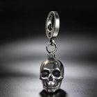 Adult male hand holding the solid silver skull key fob in an open palm to highlight its weighted scale and finish.