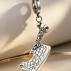 Adult male hand holding the solid steel pendant key fob in an open palm to highlight its weighted scale and finish.