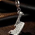 Macro photograph displaying the weathered surface texture, deburred bevels, and oxidized shadow lines of the steel pendant.