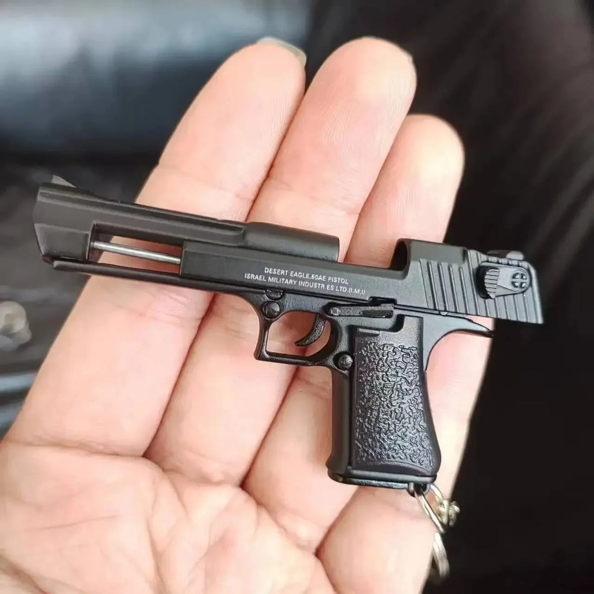 Metal 1:4 scale Desert Eagle style model keychain in black finish, alloy decorative collectible shown in hand