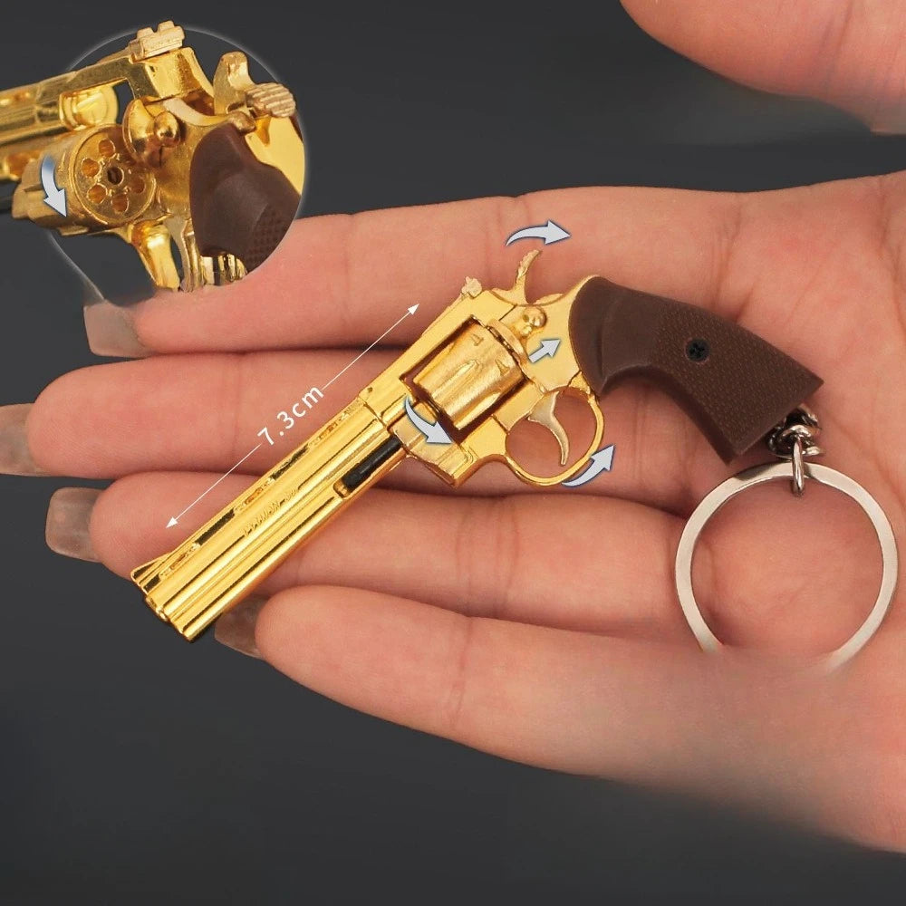 Gold alloy revolver keychain shown in hand with rotating cylinder and 7.3cm size reference