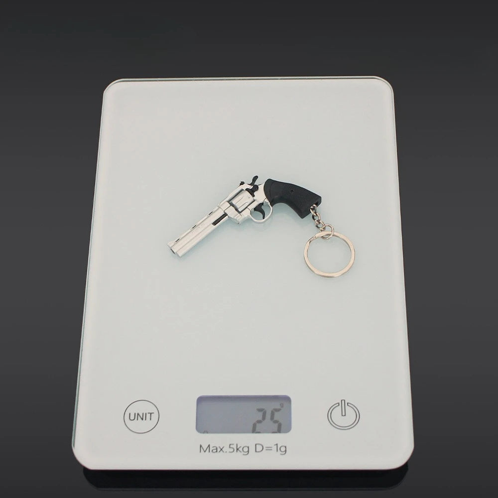Silver alloy revolver keychain on digital scale showing 2.5g weight