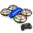 Blue mini camera drone with four illuminated rotor guards and matching remote controller on a white studio background.