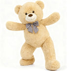Beige teddy bear with a blue bow tie on a white background