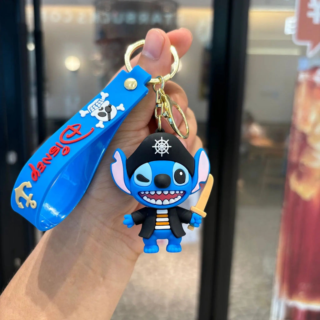 Blue alien pirate cartoon PVC keychain with wrist strap, held in hand