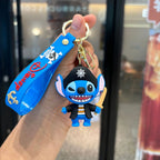 Blue alien pirate cartoon PVC keychain with wrist strap, held in hand