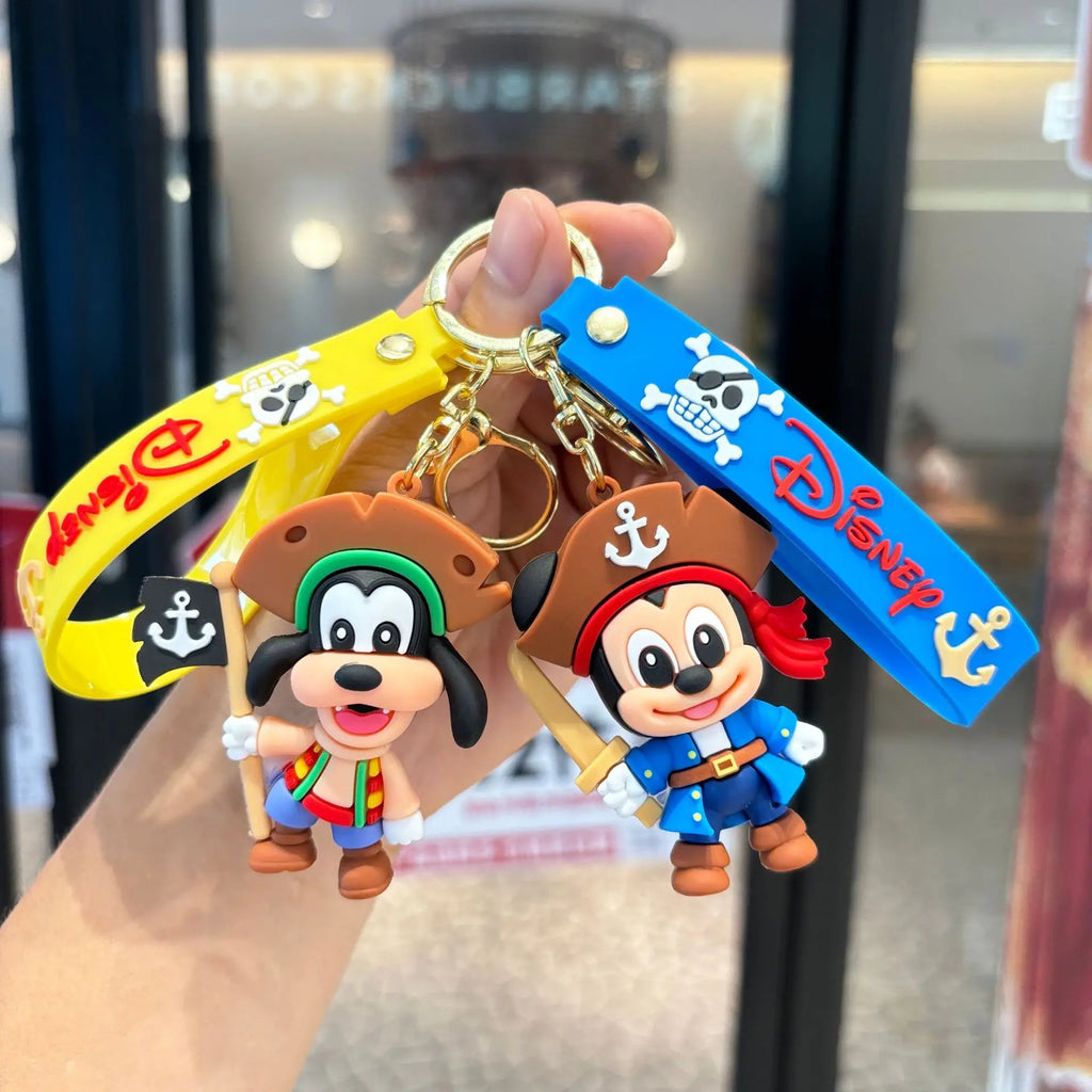 Pirate cartoon keychains featuring a mouse captain and dog pirate with colorful wrist straps, held in hand