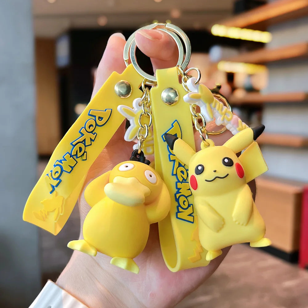 Pikachu and Psyduck Pokémon plush keychain hangers with yellow straps, held in hand Main image