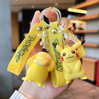 Pikachu and Psyduck Pokémon plush keychain hangers with yellow straps, held in hand