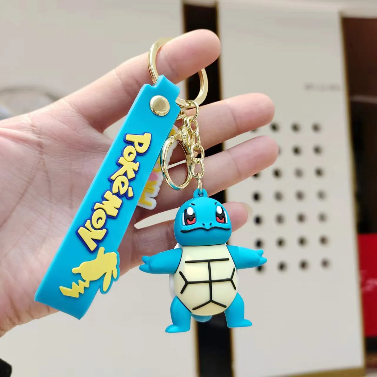 Squirtle Pokémon plush keychain hanger with blue strap held in hand