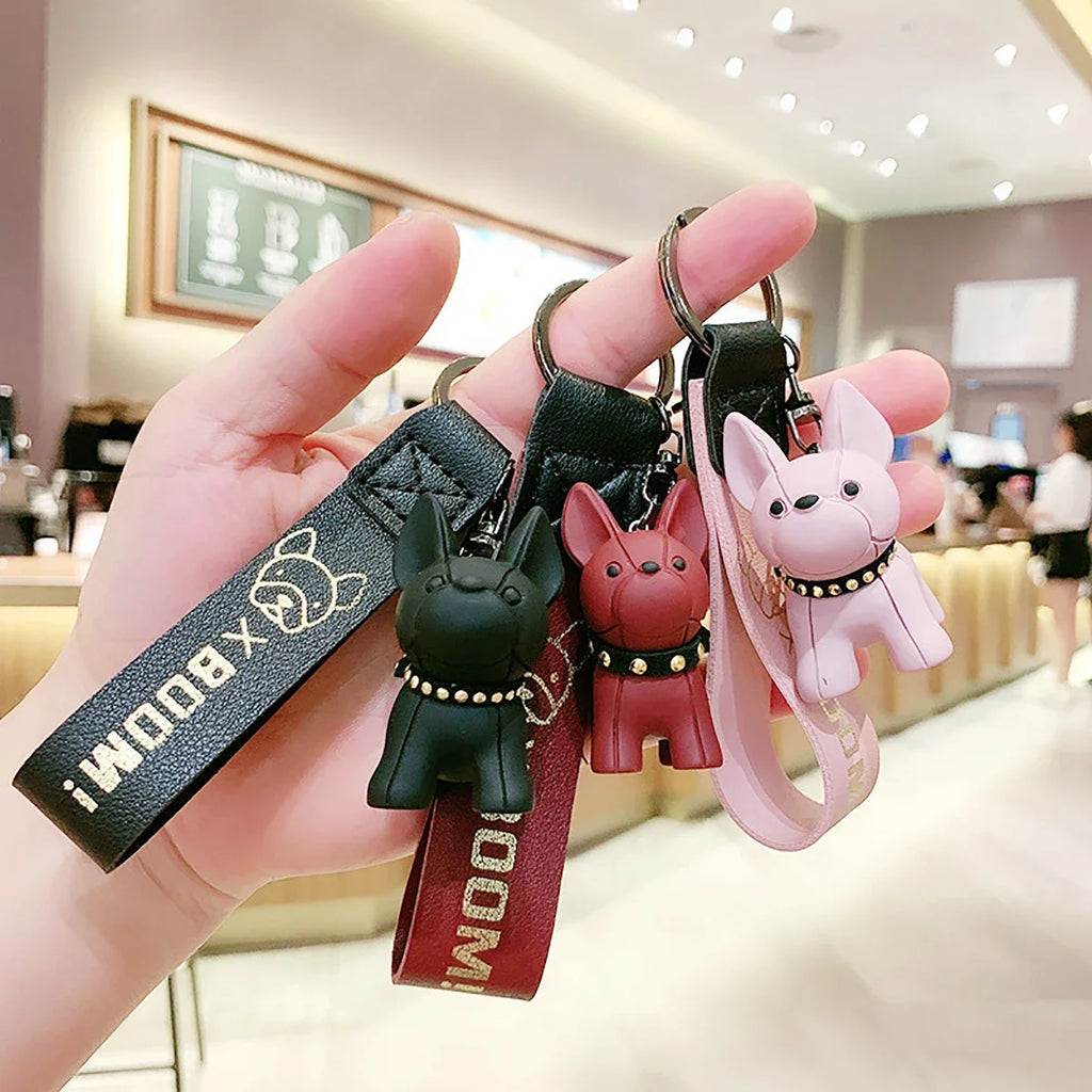 Punk French bulldog keychains in black, red, and pink held in hand, PU leather dog bag and car keyrings