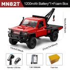 Red toy truck with crane, remote control, battery, and foam box on a white background