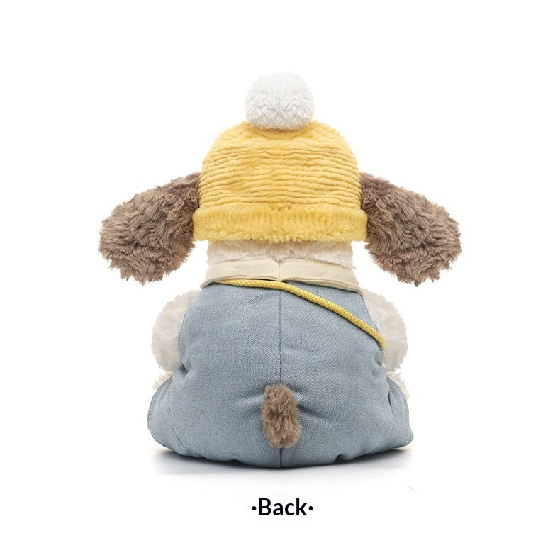 Stuffed animal toy with a yellow sweater and blue pants on a brown background