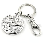 Adult hand holding the solid stainless steel skull compass in an open palm to highlight its weighted scale and metallic finish.