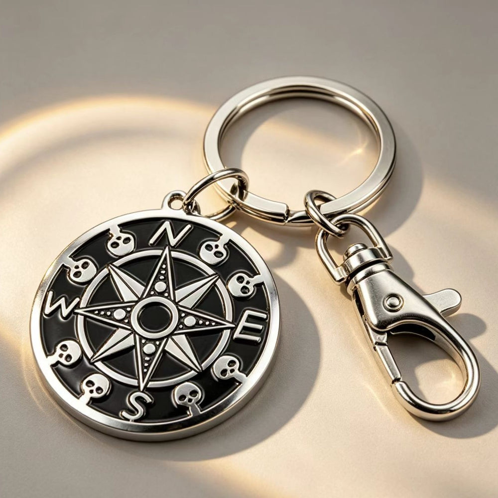 The silver skull compass keychain attached to car keys and a remote fob resting on a rustic wooden surface.