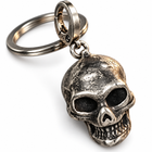 Close-up of the skull keychain showing its textured antique-silver finish, dark eye sockets, and sculpted teeth.