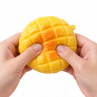Hands squeezing the yellow pineapple bun sensory toy