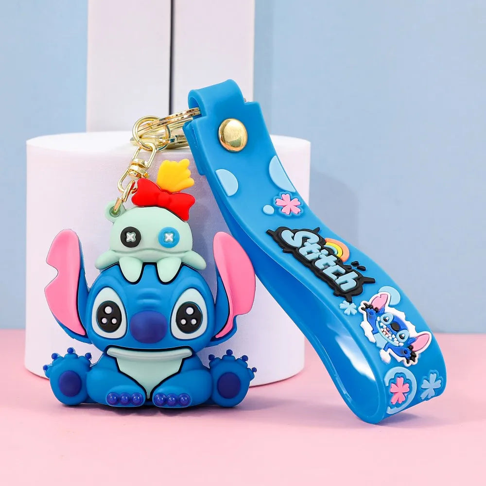 Stitch-style blue cartoon character keychain sitting pose with silicone wrist strap on pastel background