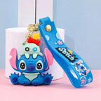 Stitch-style blue cartoon character keychain sitting pose with silicone wrist strap on pastel background