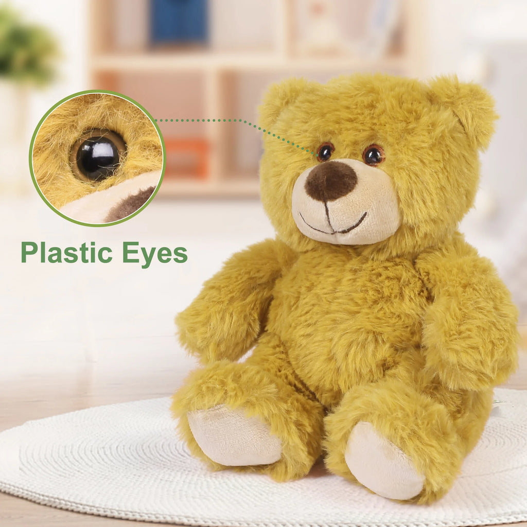 Yellow teddy bear with a close-up of its plastic eye on a white surface.