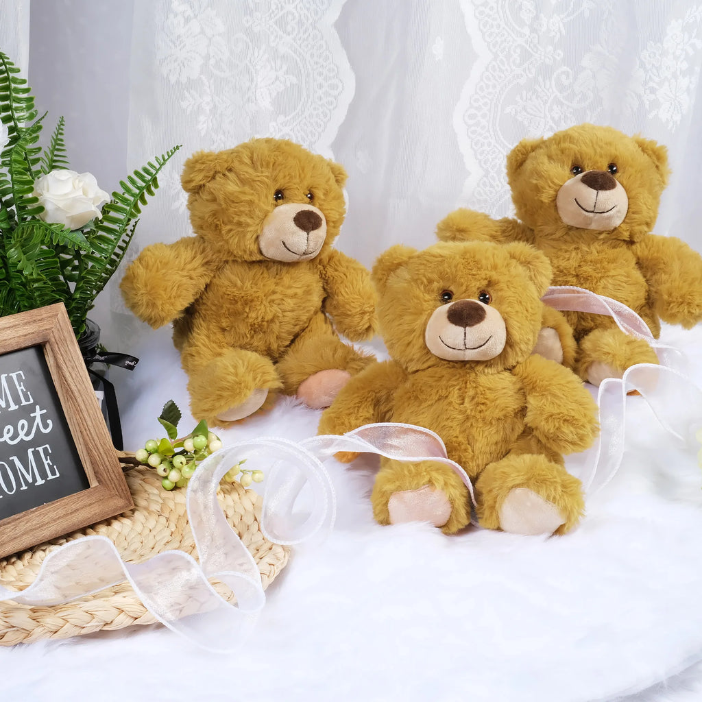 Three brown teddy bears with ribbons on a white surface with decorative elements.