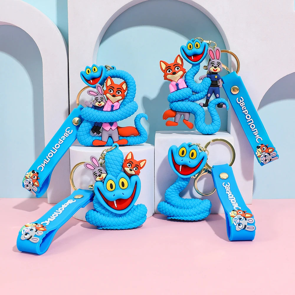 Set of blue cartoon snake keychains with different poses and straps, displayed together on pastel blocks