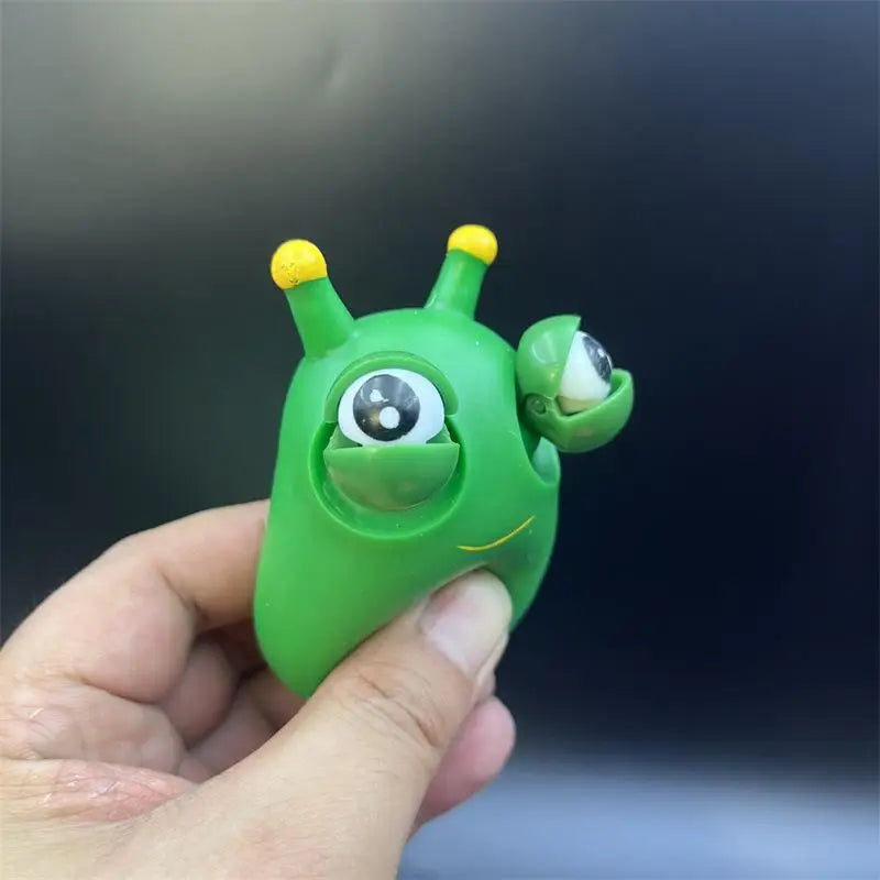 Green pop-out eyes dragon squeeze fidget toy close-up with eyes popping out while being squeezed