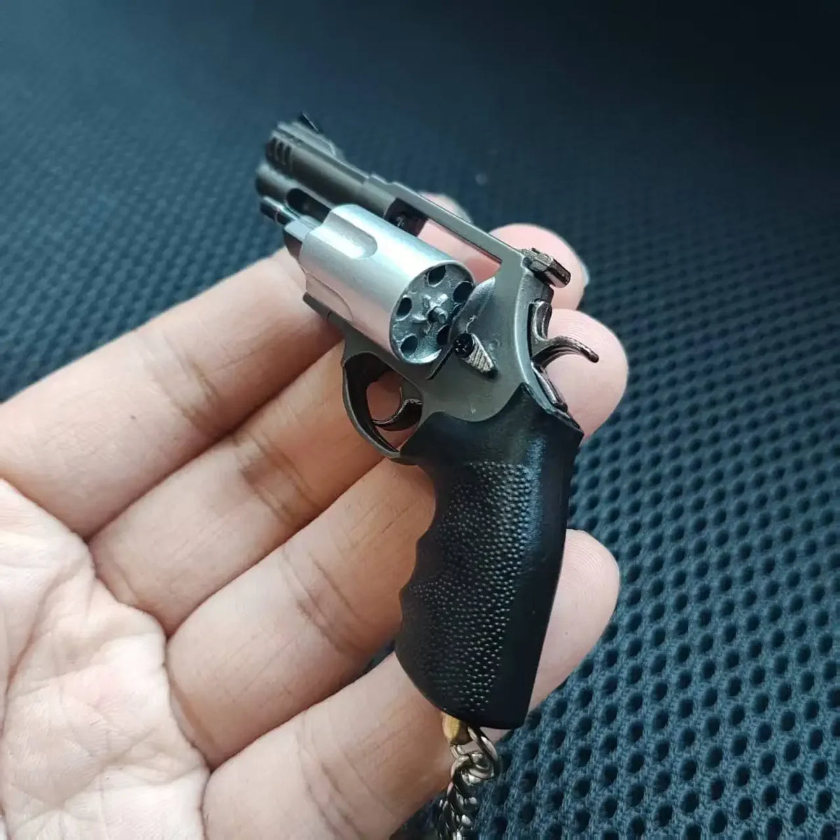 Close-up of mini M500 revolver metal keychain collectible cylinder and grip detail