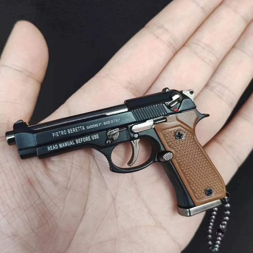 Classic style mini scale pistol model keychain with brown grip held in hand, decorative metal collectible