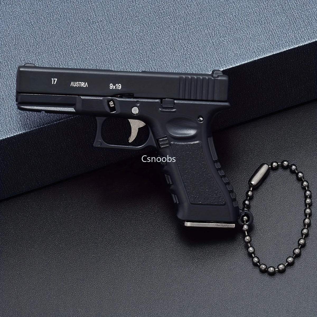 Mini scale black pistol model keychain displayed on a box with chain, metal decorative collectible