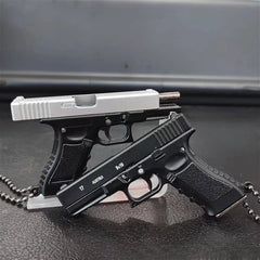 Stacked mini scale pistol model keychains on a dark background, metal collectible models