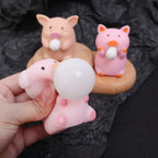 Pink pig bubble squishy toy blowing bubble with other pig fidget toys displayed behind, soft sensory stress relief toy