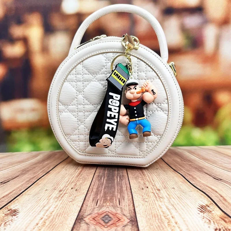 Toylvia Popeye Kawaii Keychain attached to white round handbag for display.