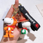 Snoopy silicone keychain set with orange suit and hat style held in hand