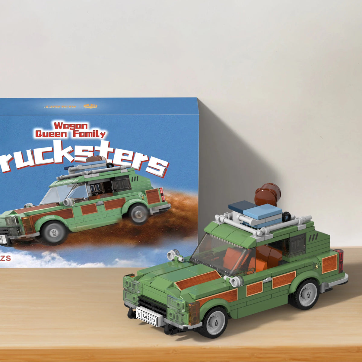 Model of a green and brown truck resembling a classic vehicle, with a box featuring similar design in the background.