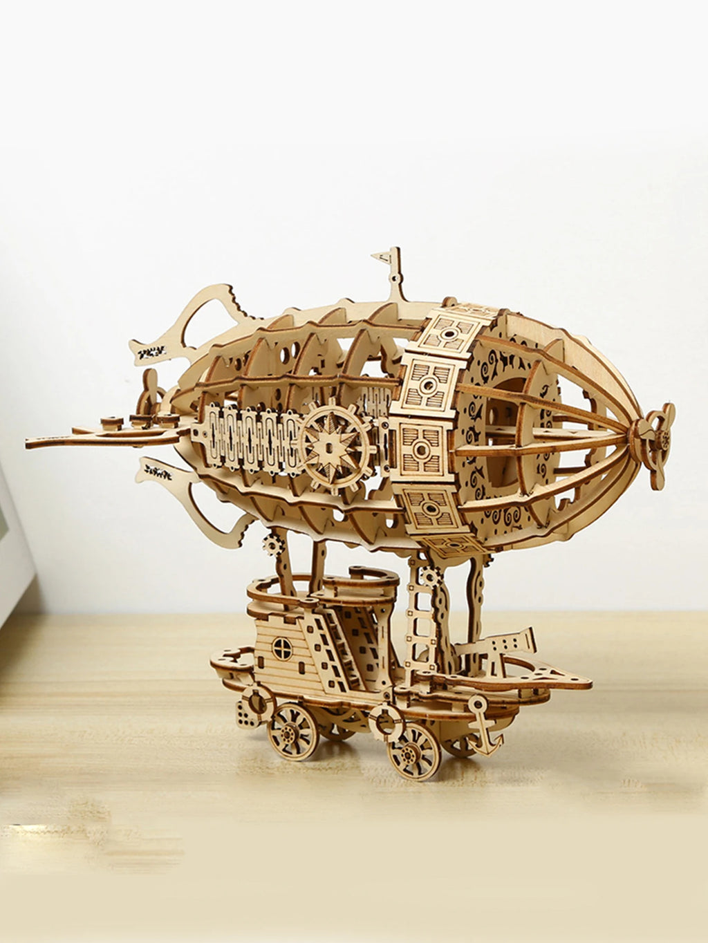 Wooden steampunk airship 3D puzzle model kit displayed on a wooden surface